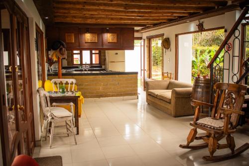 een woonkamer met een bank en een tafel en stoelen bij El Pozzo Hotel Campestre in Villa de Leyva