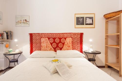 a bedroom with a white bed with a red headboard at Al Quadrifoglio Bed & Breakfast in Verona