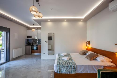 a bedroom with a large bed and a kitchen at Olia seaside residence 120m from the beach in Pefkochori