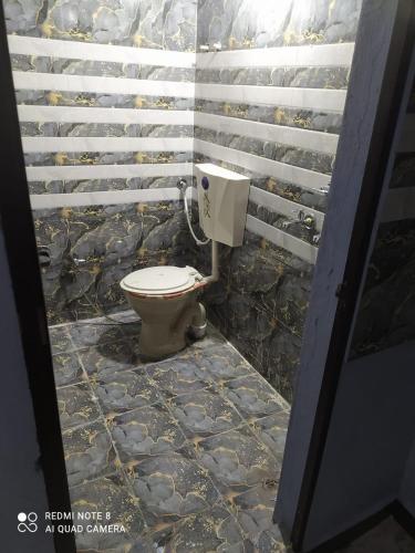 a bathroom with a toilet in a stone wall at Mangal kripa homestay in Ujjain