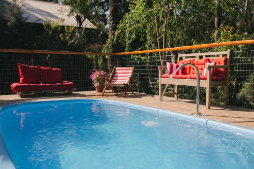 una gran piscina con 2 sillas y un banco en Recanto de Encantos, en Campos do Jordão