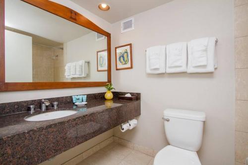 W łazience znajduje się umywalka, toaleta i lustro. w obiekcie Hotel room on the strip in Kalakaua Ave views L903 w mieście Honolulu