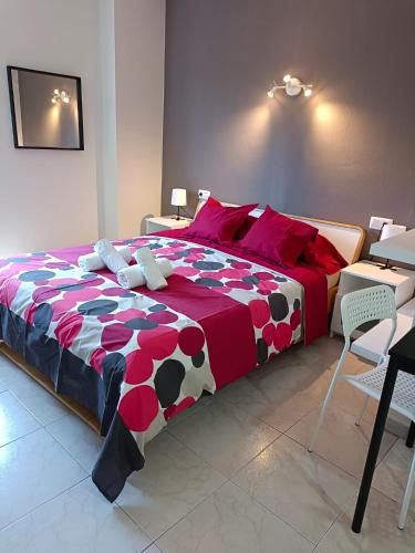 sypialnia z dużym łóżkiem z czerwonym i białym kocem w obiekcie Apartamentos Carrillo 6 w mieście Santa Cruz de Tenerife