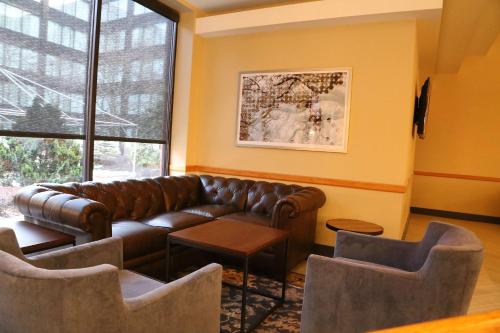 a living room with a leather couch and chairs at DoubleTree by Hilton Boston-Andover in Andover