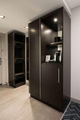 a kitchen with a large black refrigerator in a room at Hilton Garden Inn Foxborough Patriot Place in Foxborough