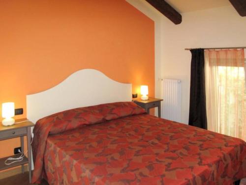a bedroom with a bed and two tables and a window at Cà Mia - Casa vacanze nelle vigne del Barolo in Serralunga d'Alba
