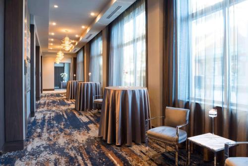 a row of tables and chairs in a room with windows at Hilton Garden Inn Foxborough Patriot Place in Foxborough