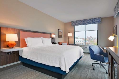 una camera d'albergo con letto, scrivania e finestra di Hampton Inn Salem, Ma a Salem