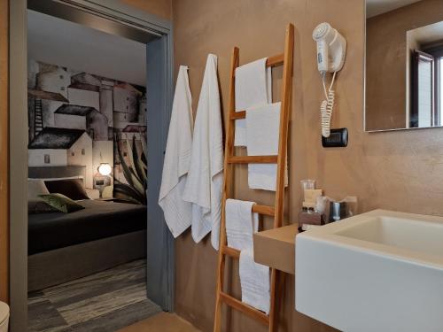 a bathroom with a sink and a bed in a room at "Locanda Susuiusu" keyless entry in Enna
