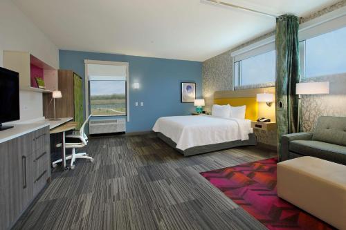 a large hotel room with a bed and a tv at Home2 Suites By Hilton Beaumont, Tx in Beaumont