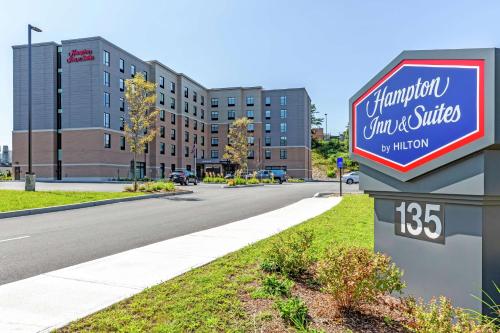 a sign for a hotel on the side of a street at Hampton Inn & Suites Boston/Waltham in Waltham