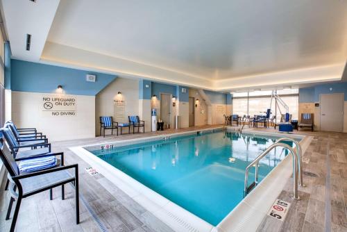a pool in a hotel room with chairs at Hampton Inn & Suites Boston/Waltham in Waltham