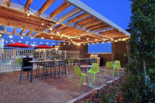 a patio with tables and chairs and lights at Home2 Suites By Hilton Port Arthur in Port Arthur