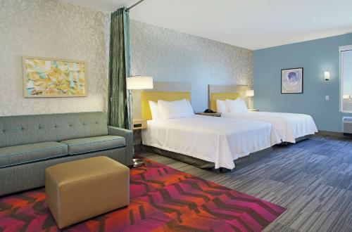 Habitación de hotel con 2 camas y sofá en Home2 Suites By Hilton Port Arthur en Port Arthur