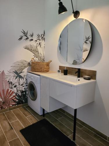 - un lave-linge dans la salle de bains pourvue d'un miroir dans l'établissement L'entre-deux, à Périgueux