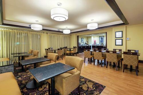 a restaurant with tables and chairs in a room at Hampton Inn I-10 & College Drive in Baton Rouge