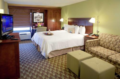 バトンルージュにあるHampton Inn I-10 & College Driveのベッドとテレビが備わるホテルルームです。