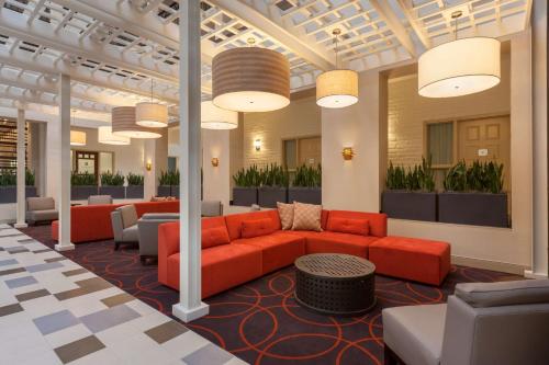 a lobby with a couch and chairs and pendant lights at Embassy Suites Baton Rouge in Baton Rouge
