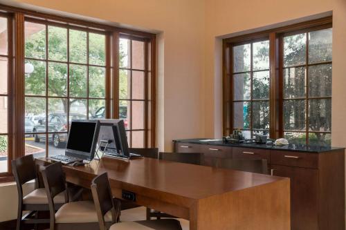 an office with a desk with a laptop on it at Embassy Suites Baton Rouge in Baton Rouge