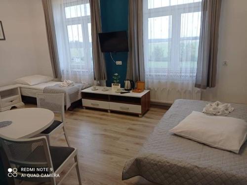 una camera d'albergo con due letti e un tavolo con sedie di Centrum Wypoczynkowe COMPLEX a Mąkoszyn