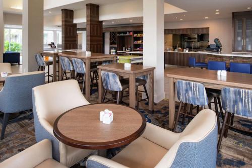 a restaurant with tables and chairs and a bar at Hilton Garden Inn Baton Rouge Airport in Baton Rouge