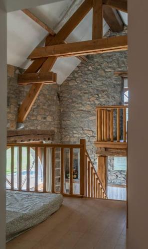 a room with a bed and a stone wall at Les 4 bras Maison de vacances in Beauraing