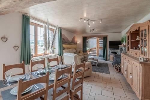 a living room with a dining table and a living room at Les 4 bras Maison de vacances in Beauraing