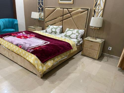 sypialnia z dużym łóżkiem i niebieskim krzesłem w obiekcie Three Bedroom Villa w mieście Lahaur