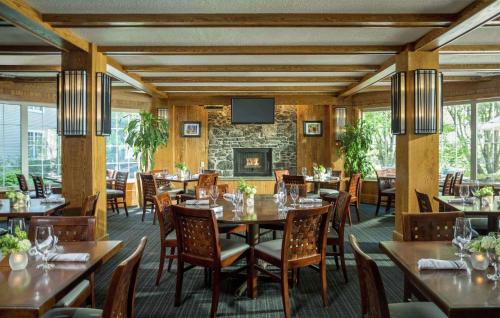 a restaurant with tables and chairs and a fireplace at DoubleTree by Hilton Hotel Burlington Vermont in Burlington