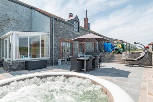 a patio with a fountain and a table with an umbrella at Les 4 bras Maison de vacances in Beauraing