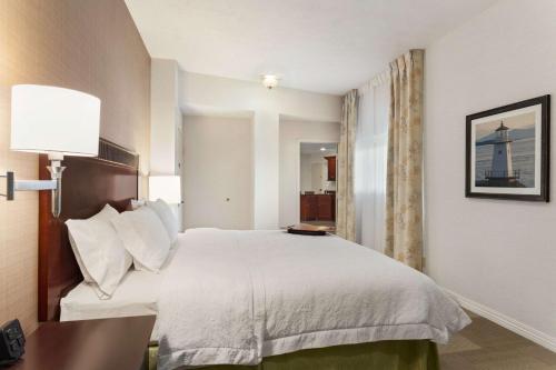 a hotel room with a large bed and a desk at Hampton Inn Burlington - Colchester in Burlington