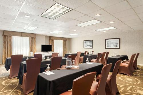 a conference room with tables and chairs and a tv at Hampton Inn Burlington - Colchester in Burlington