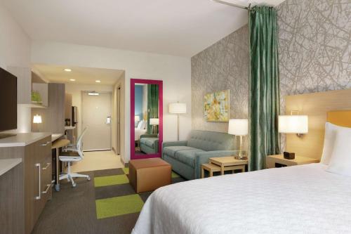 Habitación de hotel con cama y sala de estar. en Home2 Suites By Hilton Williamsville Buffalo Airport en Williamsville