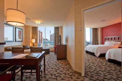 a hotel room with two beds and a living room at Embassy Suites Buffalo in Buffalo