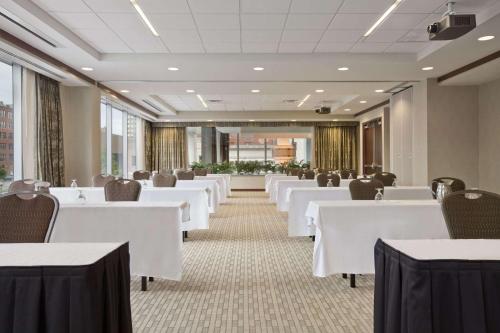 a dining room with white tables and chairs at Embassy Suites Buffalo in Buffalo