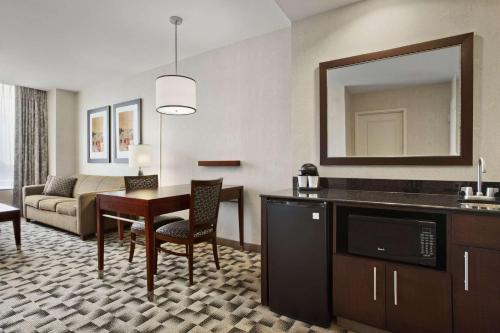 a living room with a dining table and a living room at Embassy Suites Buffalo in Buffalo