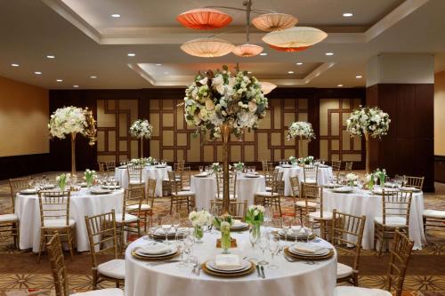 a banquet hall with white tables and chairs and flowers at Embassy Suites Los Angeles Glendale in Glendale