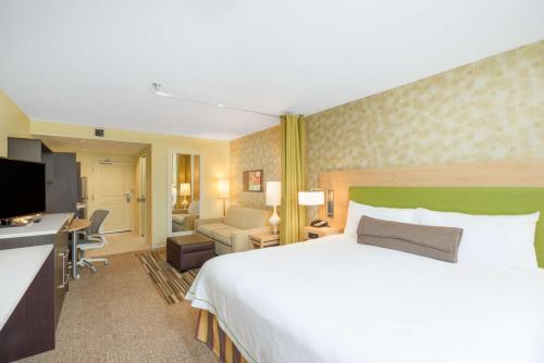 Home2 Suites By Hilton Bowling Green في بولينغ غرين: غرفة الفندق بسرير كبير ومكتب