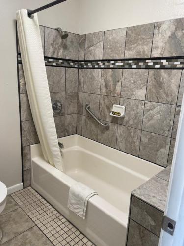 a bathroom with a tub and a toilet at Town House Motel in Sanger