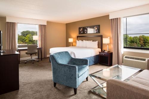 a hotel room with a bed and a chair and a couch at Doubletree by Hilton Laurel, MD in Laurel