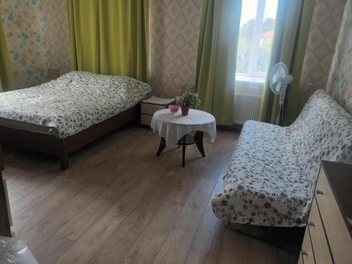 1 dormitorio con 2 camas, mesa y silla en Dzīvoklis Tukuma centrā, en Tukums
