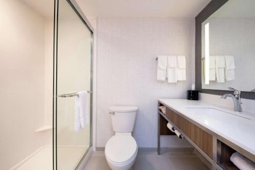 La salle de bains est pourvue de toilettes, d'un lavabo et d'une douche. dans l'établissement Hilton Garden Inn Columbia Downtown, à Columbia
