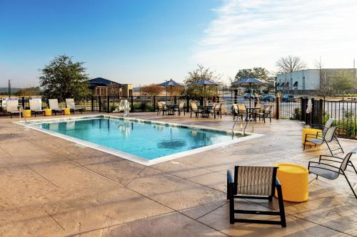 una piscina con sedie, tavoli e sedie di Hampton Inn & Suites By Hilton-Columbia Killian Road a Killian