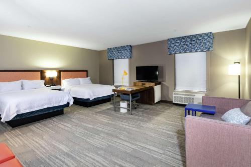 a hotel room with two beds and a flat screen tv at Hampton Inn & Suites By Hilton-Columbia Killian Road in Killian