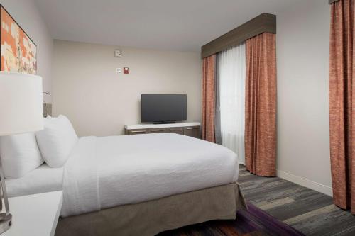 a hotel room with a bed and a television at Hilton Garden Inn Columbia Airport, SC in Columbia