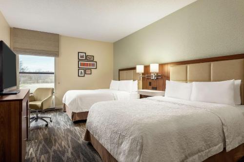 a hotel room with two beds and a flat screen tv at Hampton Inn Akron-Fairlawn in Montrose