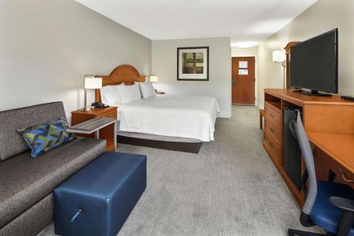 a hotel room with a bed and a flat screen tv at Hampton Inn Atlanta-Newnan in Newnan