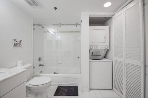 y baño blanco con aseo y ducha. en Amazing City Views from Luxurious Condo At Brickell, en Miami