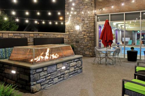 a fire pit in a patio with a table and chairs at Home2 Suites by Hilton Stow Akron in Stow
