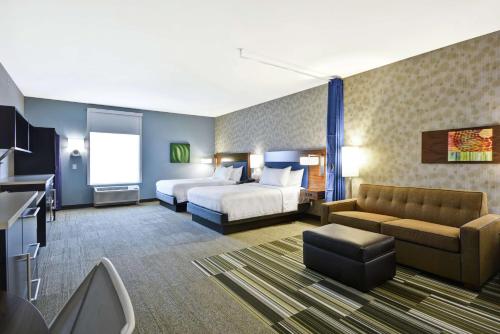 a hotel room with a bed and a couch at Home2 Suites by Hilton Stow Akron in Stow